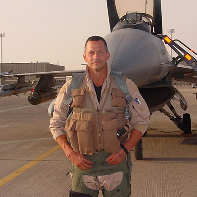 Colonel Dan Hampton hands on hips in front of airforce jet